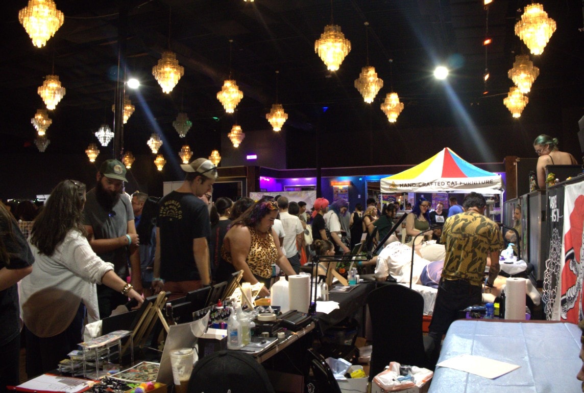 The vendor floor glowing under chandeliers — hand-crafted cat goods as far as the eye can see